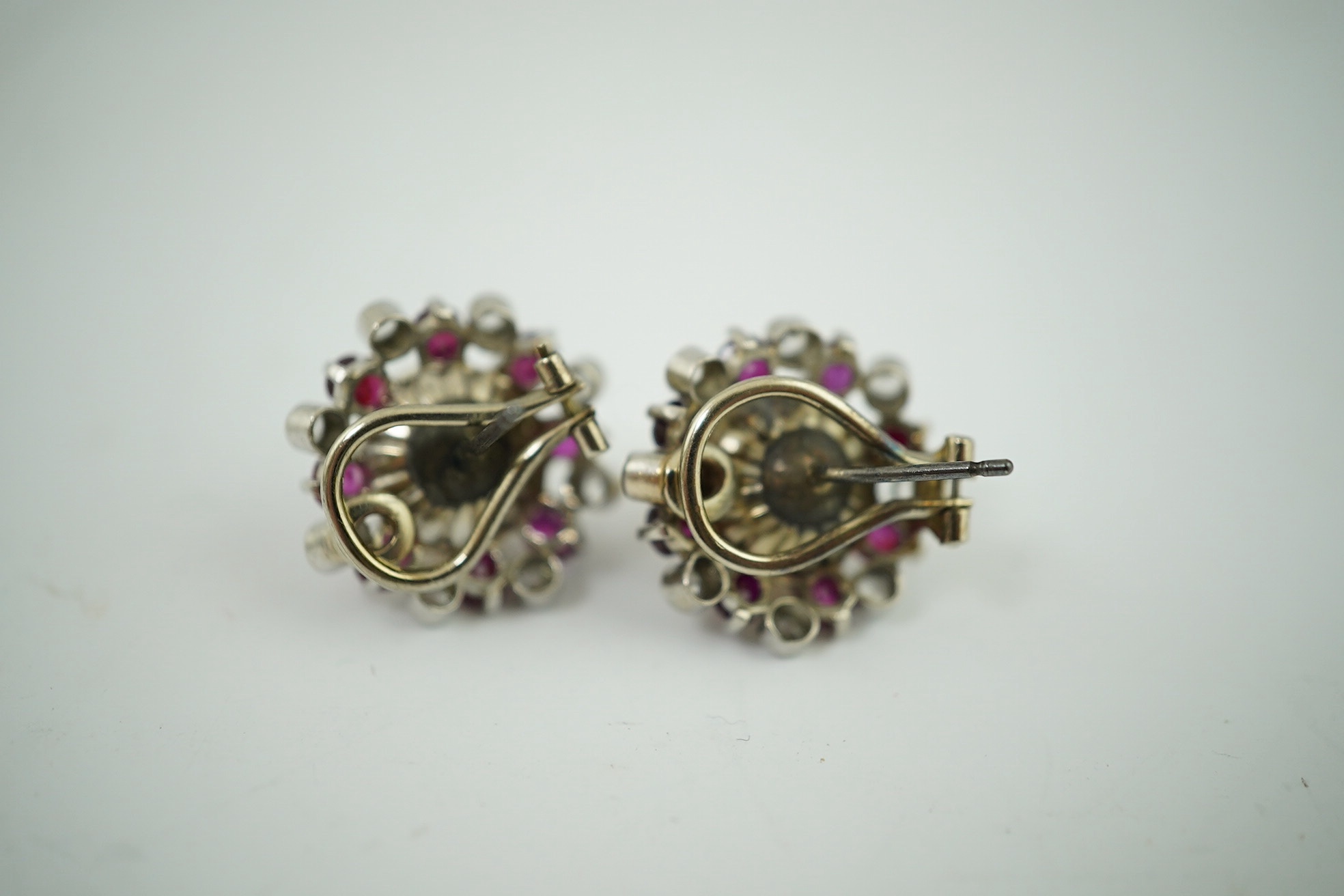 A pair of pearl earrings, with ruby and simuluated diamond surrounds, unmarked, 8.2 g gross. Condition - fair